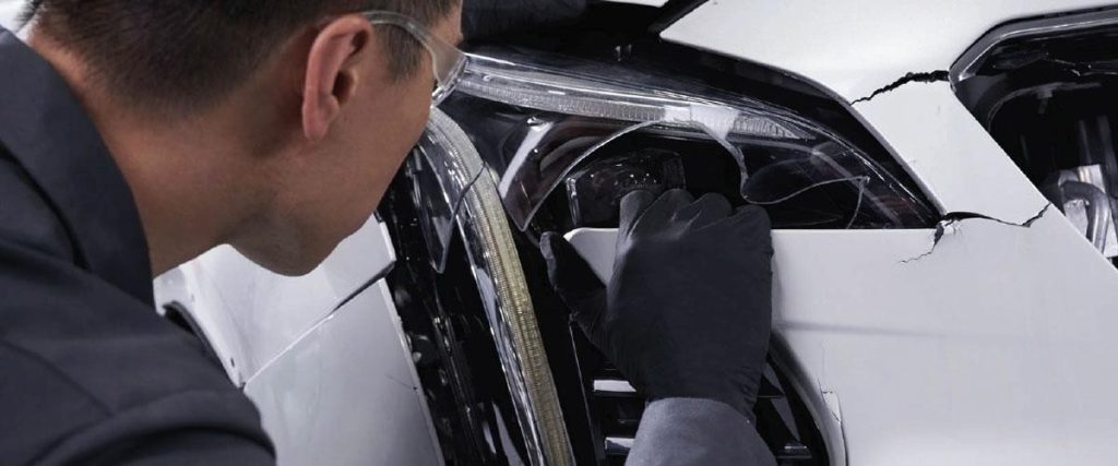 a mechanic examines a damaged vehicle in Medina, OH