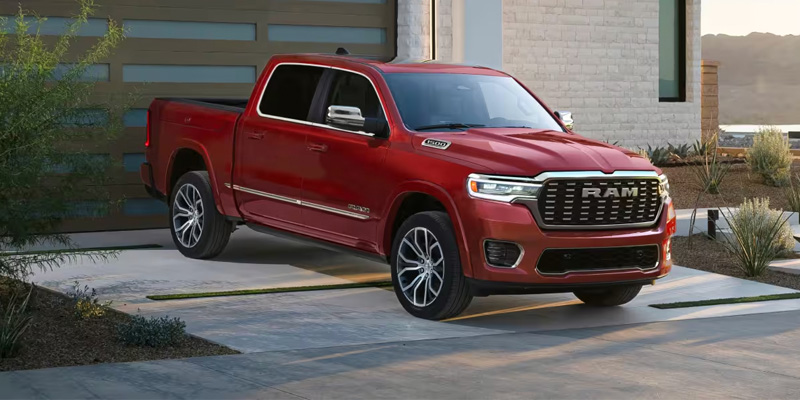 Red RAM 1500 pickup truck parked outside a modern home.
